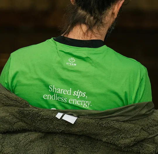 A guest seen from behind wearing a green Steam T-shirt