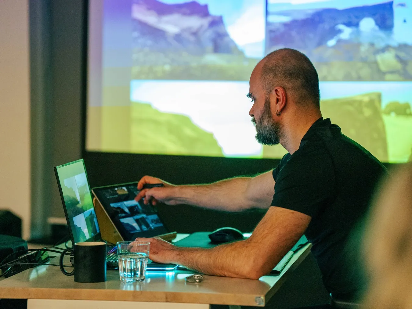 A lecturer drawing on a tablet in front of a projection