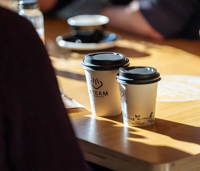 Steam takeaway cups on a sunny table