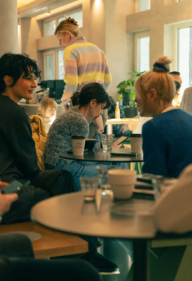 Friends around a table inside Steam