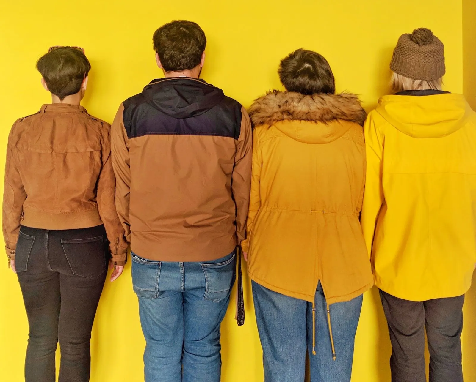 Four of us in beanies against the yellow wall