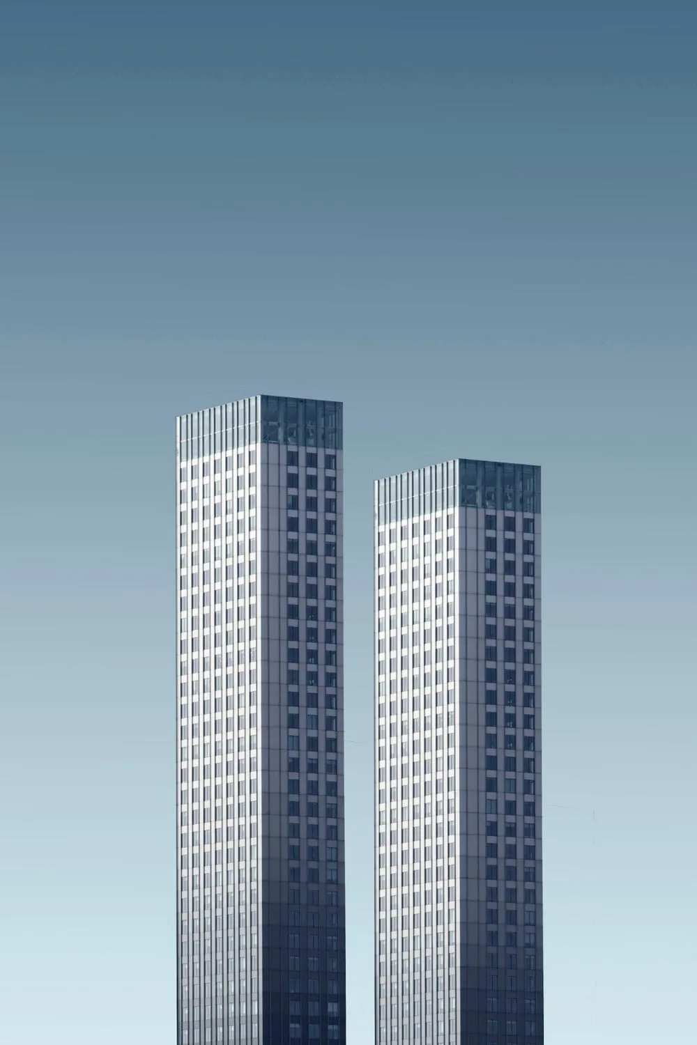 Two tall towers against a pale blue sky
