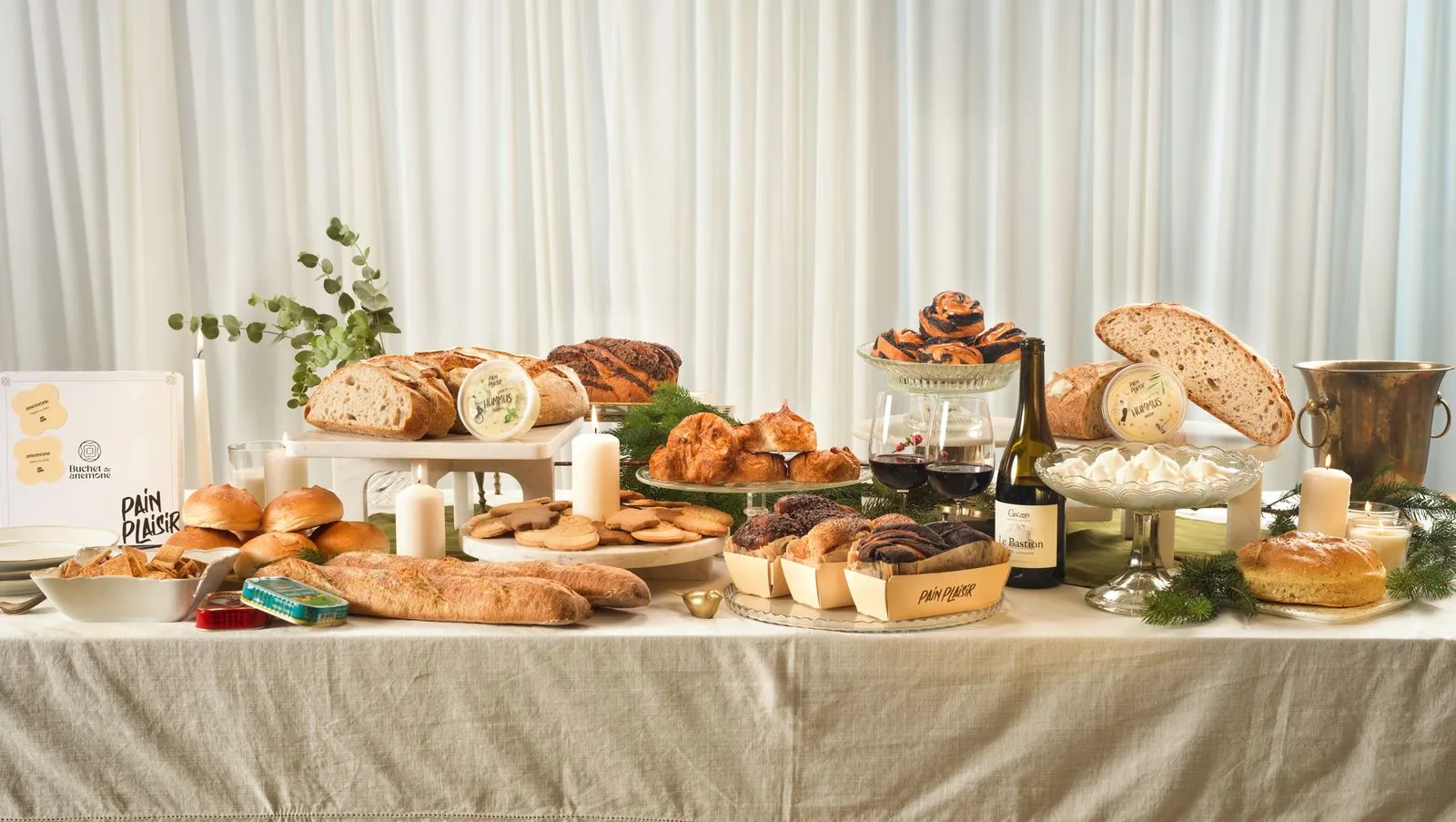 A Christmas table set with Pain Plaisir breads, pastries and the Anemone box