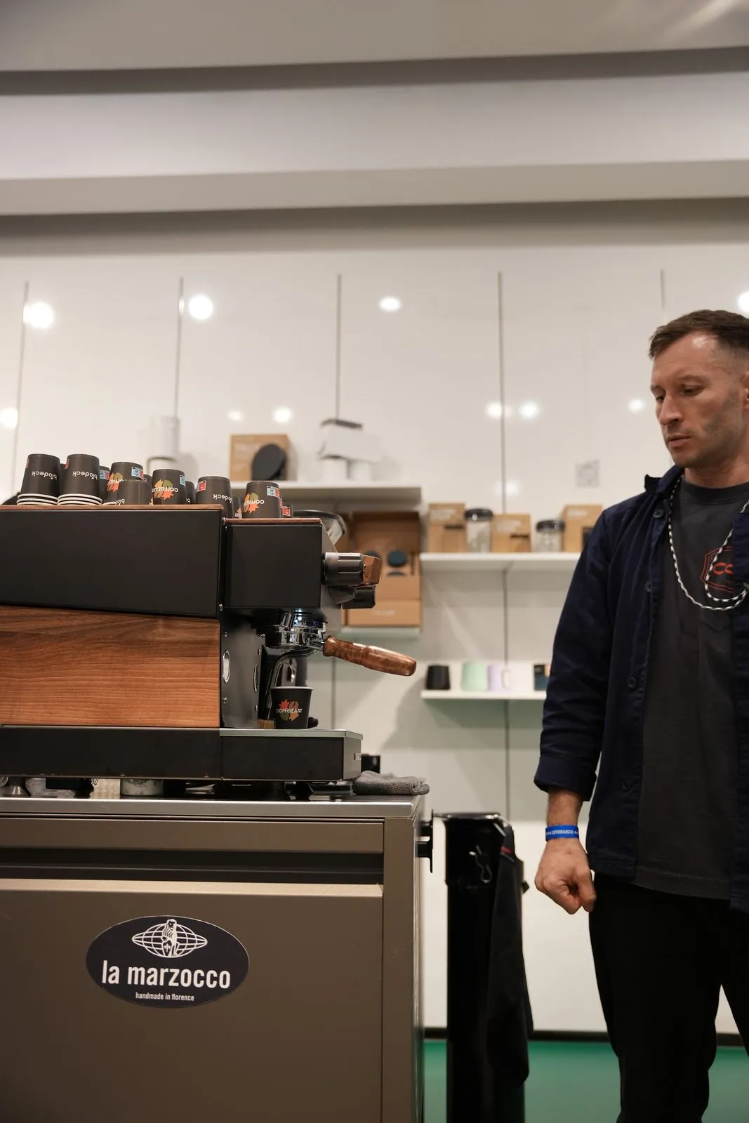 A team member next to a La Marzocco machine