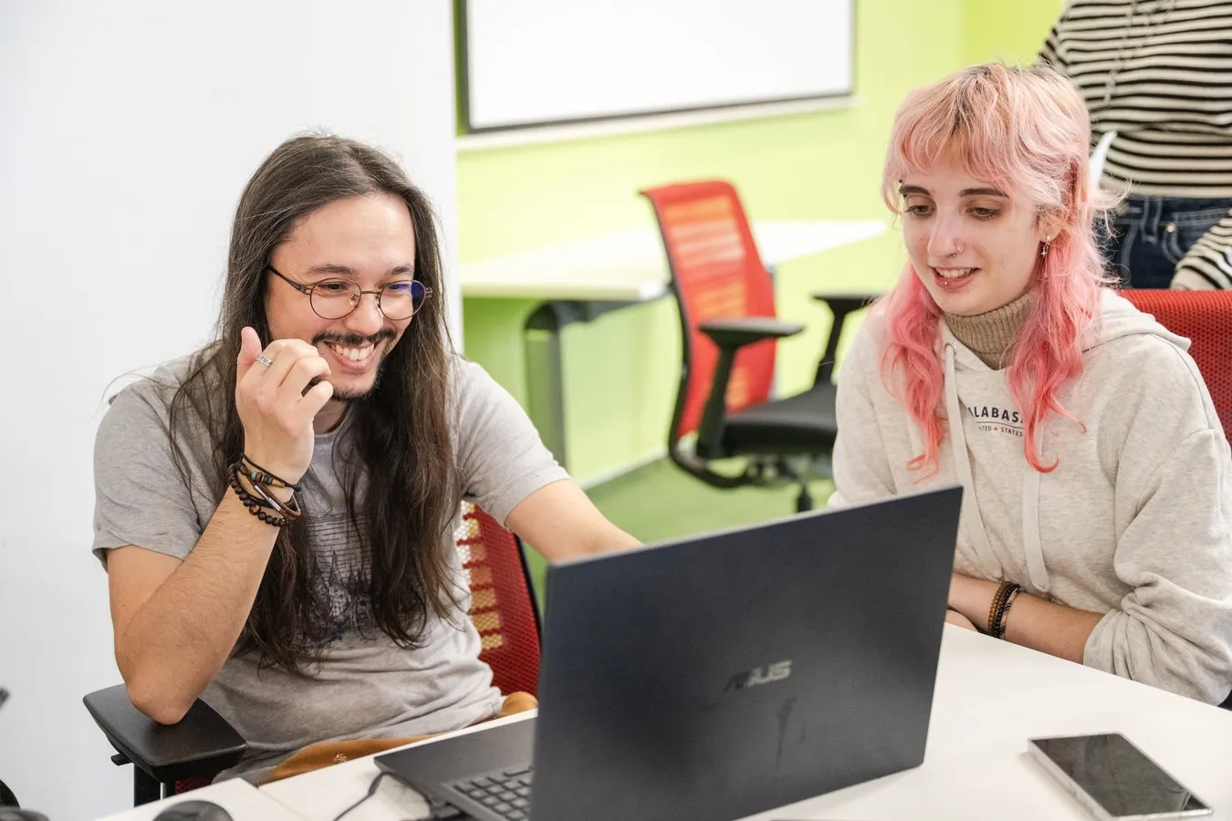 Two students laughing at a laptop