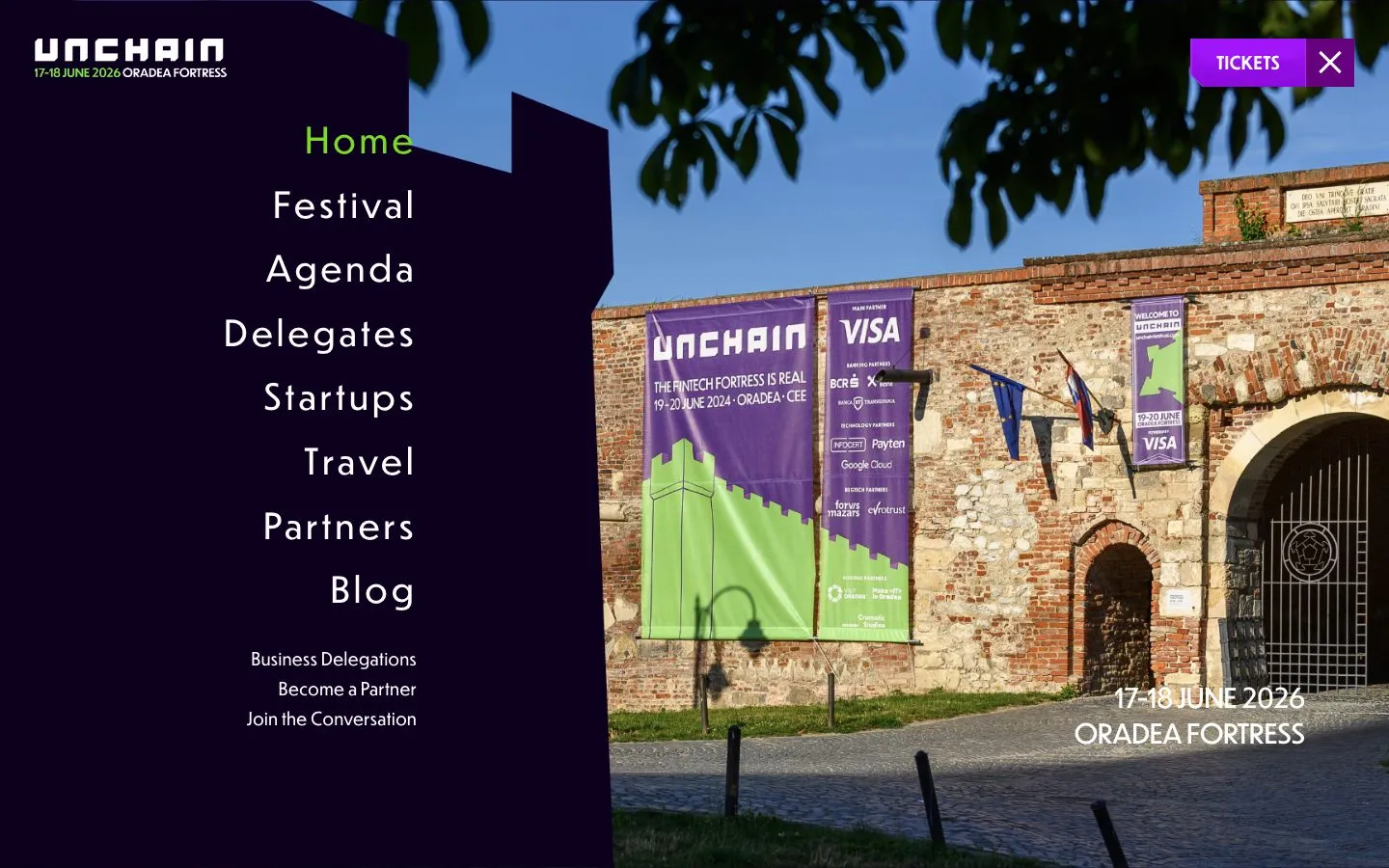 Meniul deschis: Home, Festival, Agenda, Delegates, Startups, Travel, Partners, Blog, lângă o fotografie cu poarta cetății