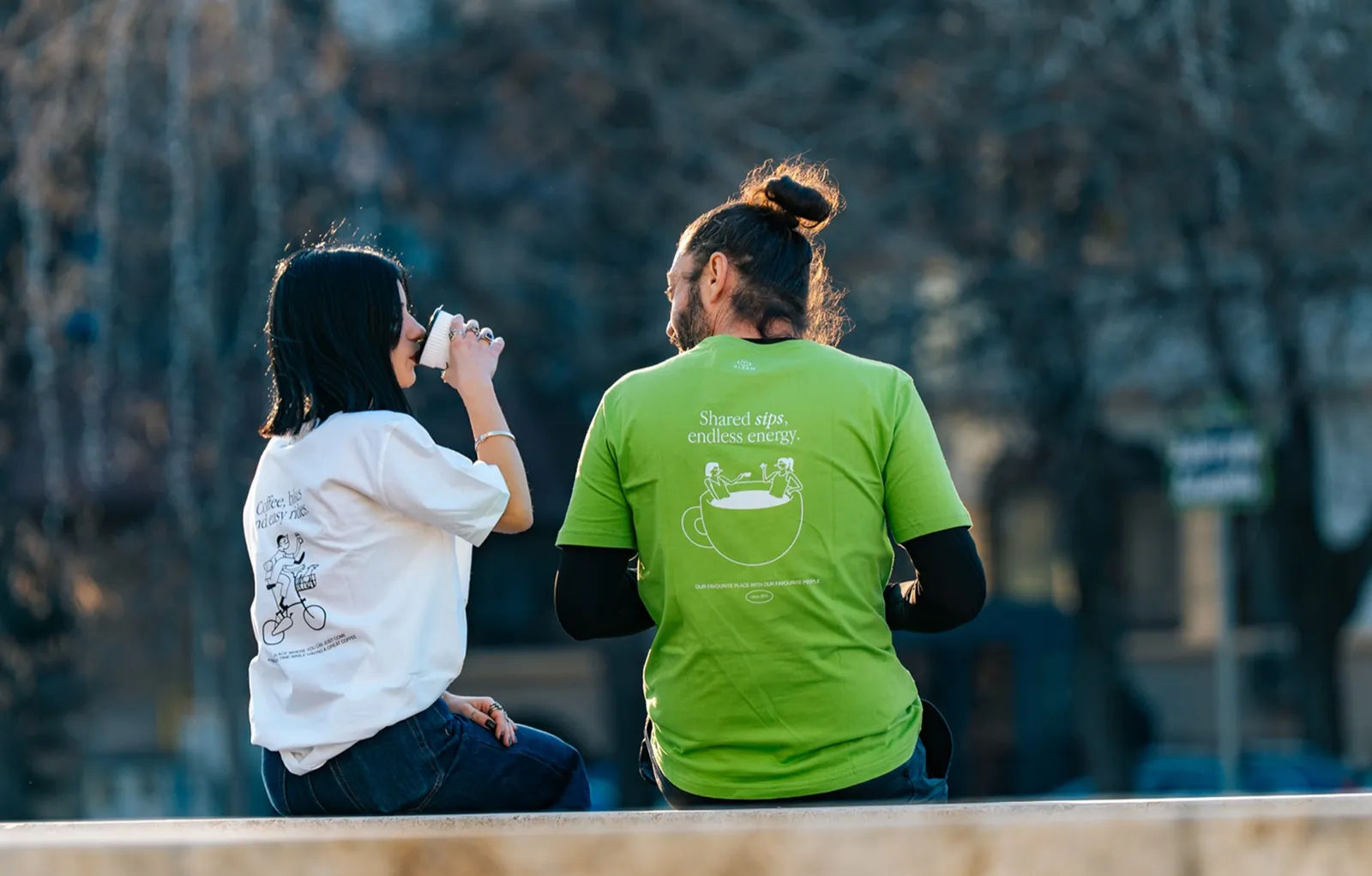 Guests in green Steam T-shirts drinking coffee outside
