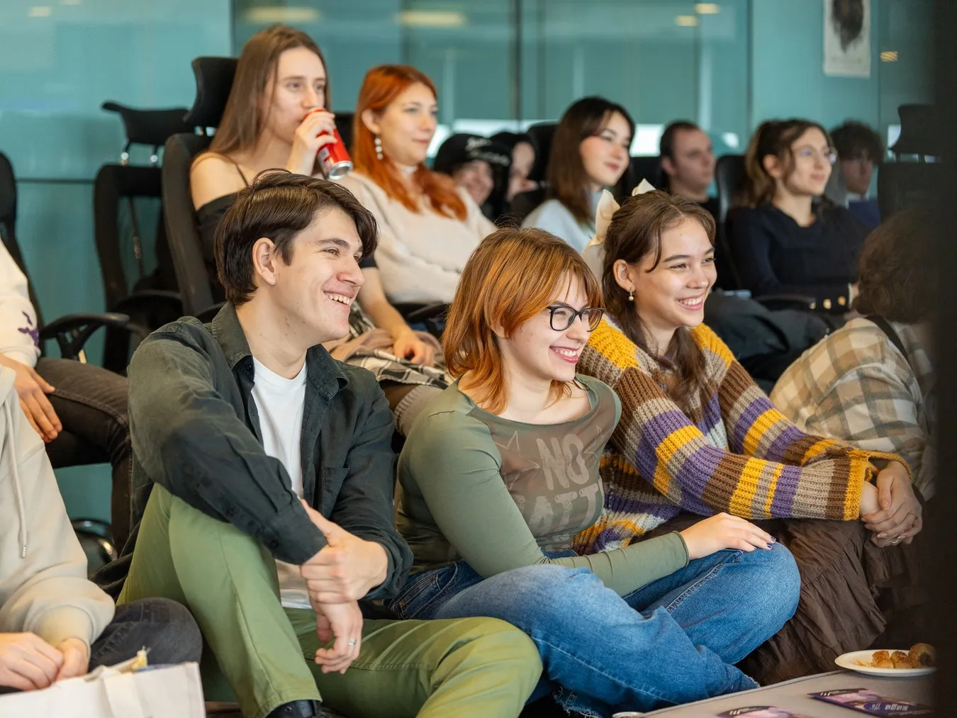 An audience of students listening and smiling