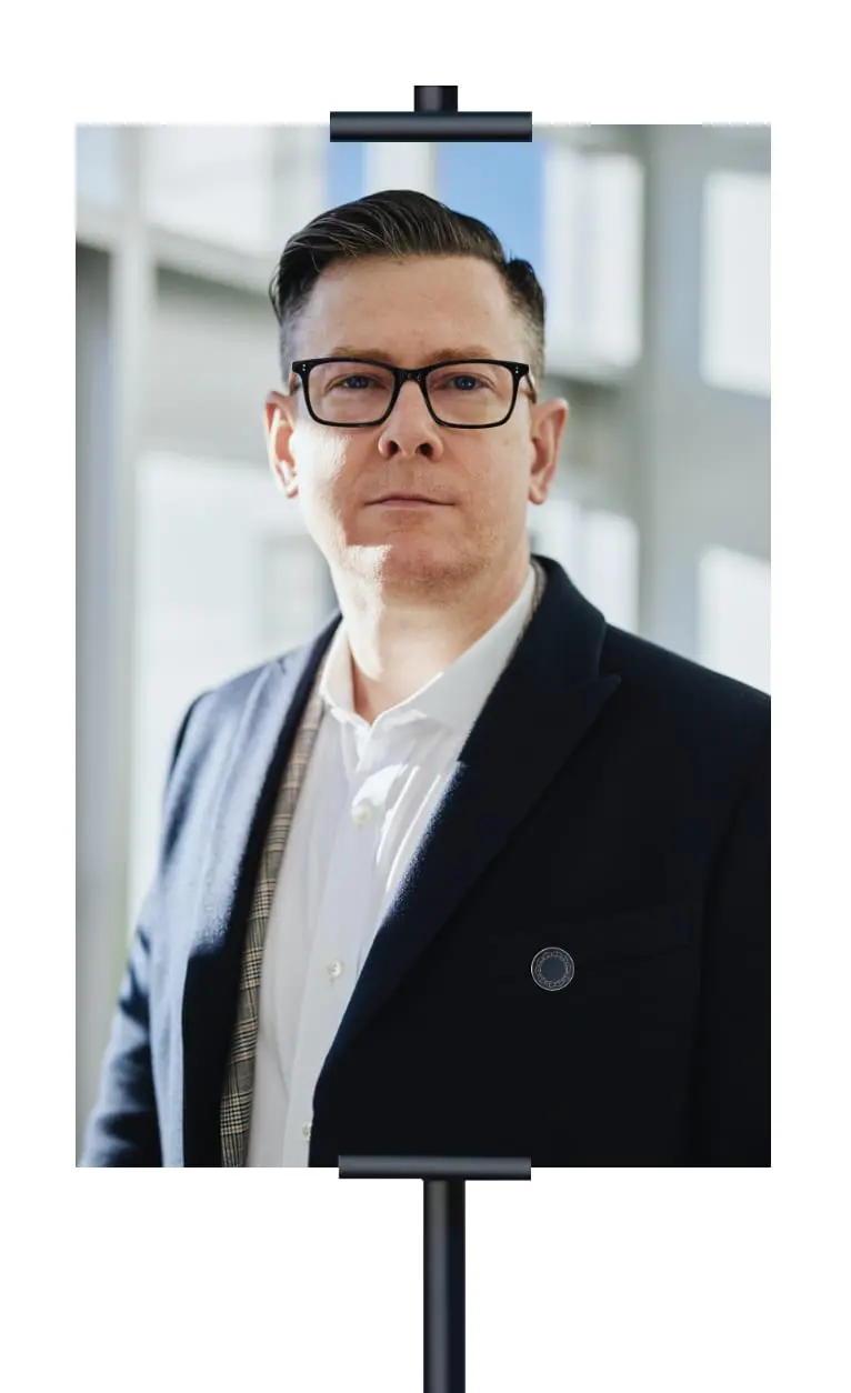 A portrait on a stand: a man in a dark suit, the ring pin on his lapel