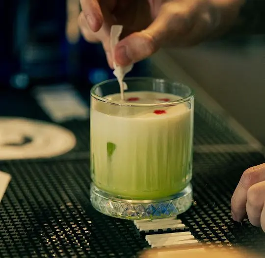Un cocktail verde, finisat la bar