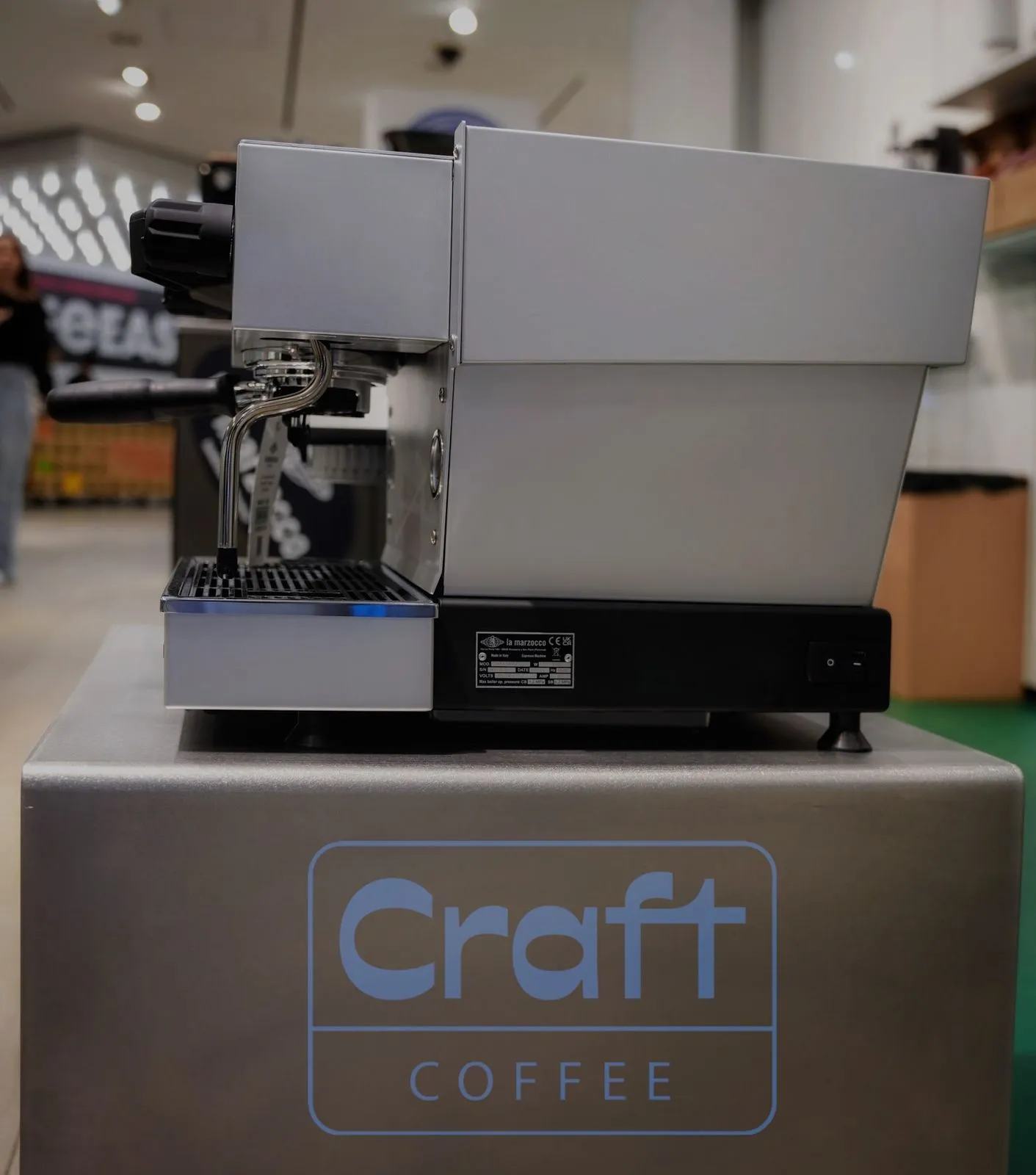 A La Marzocco espresso machine on a plinth with the Craft Coffee logo