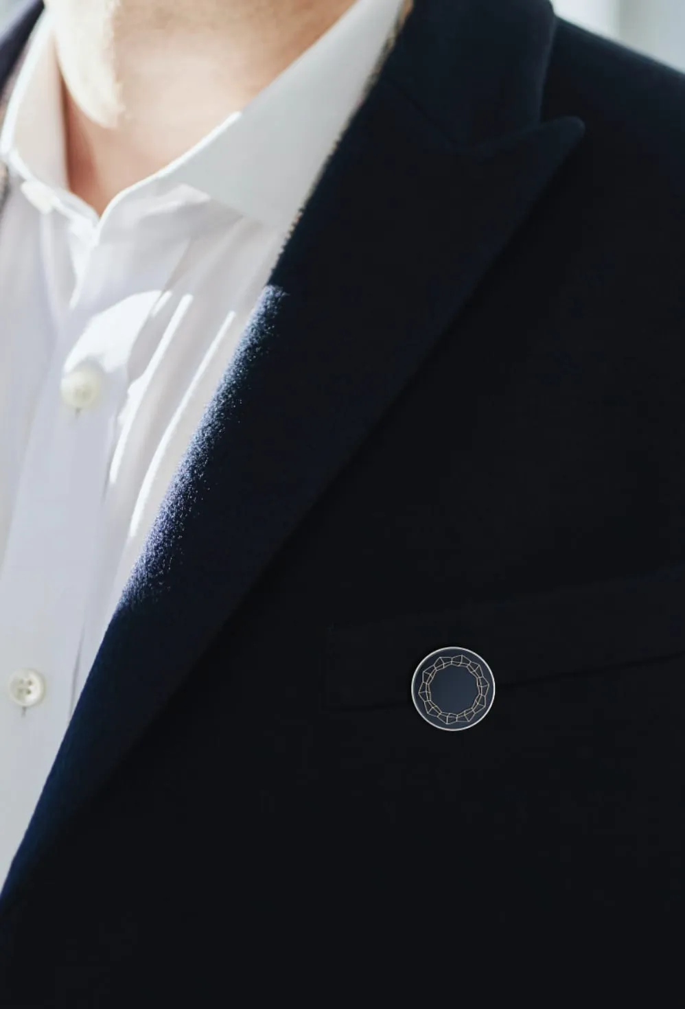 Close-up of the ring pin on the lapel of a navy jacket